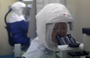 A doctor uses a microscope to look at virus samples in a Biosafety Level III laboratory in Lima